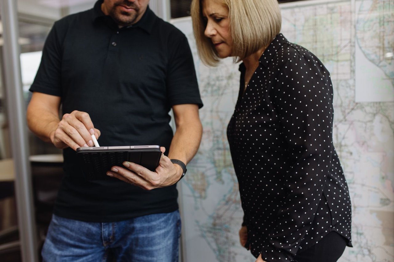 Sun State team member reviewing reefer trailer specifications on a tablet with a customer