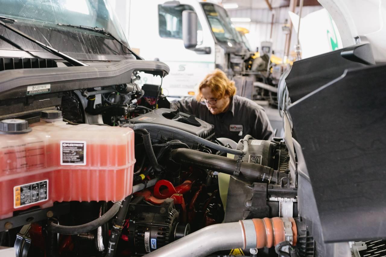 Sun State International service technician installing quality replacement parts on an International truck engine