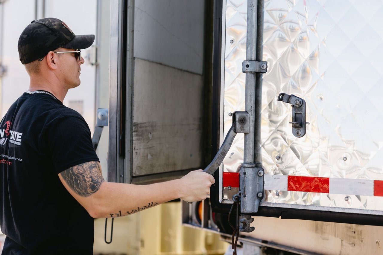 Sun State technician checking a dry van trailer's rear door latch and hardware