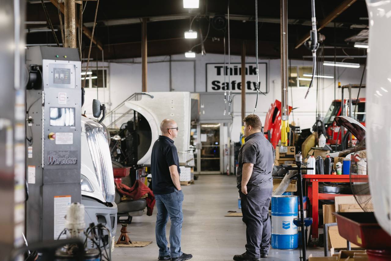 Sun State International team members reviewing a fleet truck in the service facility
