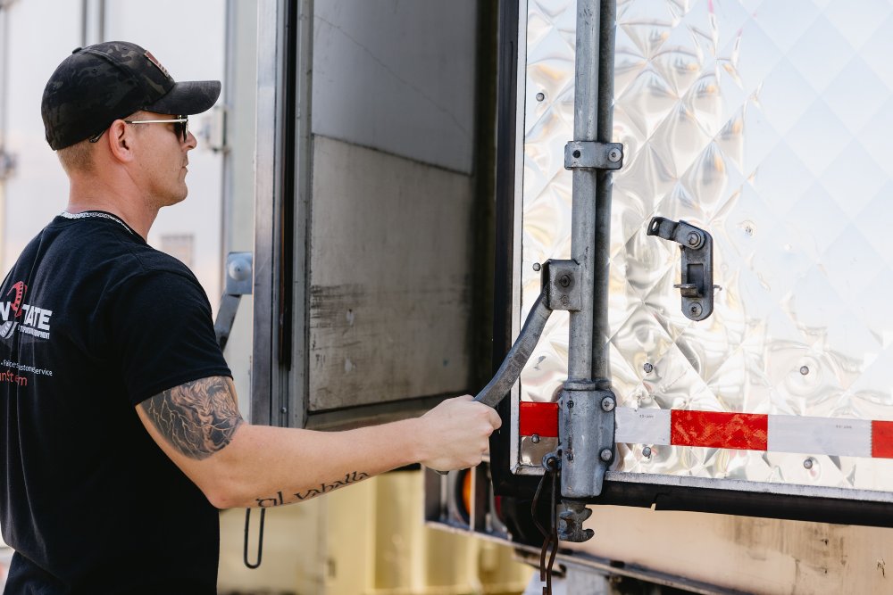 Sun State technician checking a dry van trailer's rear door hardware and locking mechanism