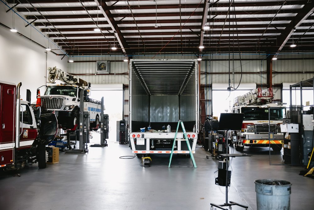 Sun State service bay with a dry van trailer and fire trucks in for maintenance