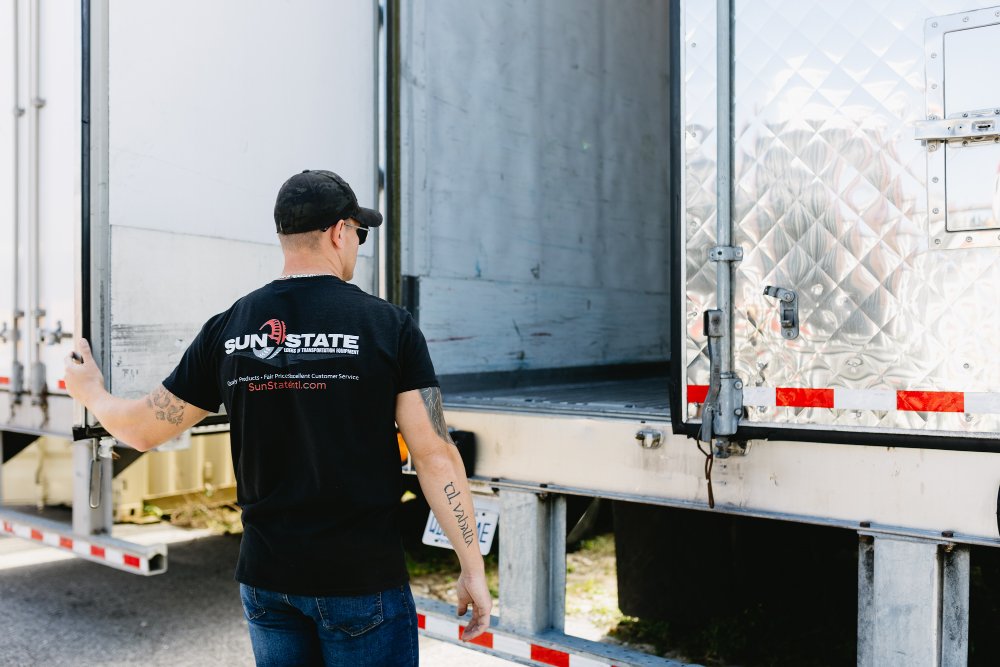 Sun State team member opening the rear doors of a dry van trailer