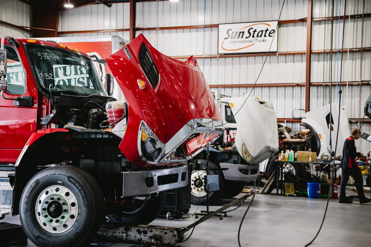 Technicians servicing International trucks inside the Sun State International shop