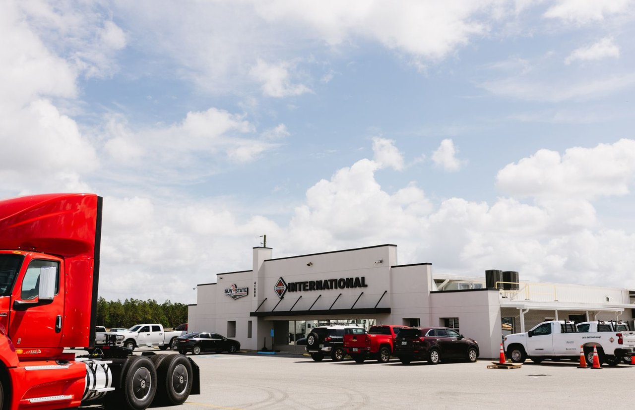 Sun State International dealership building with a red semi-truck parked in the lot