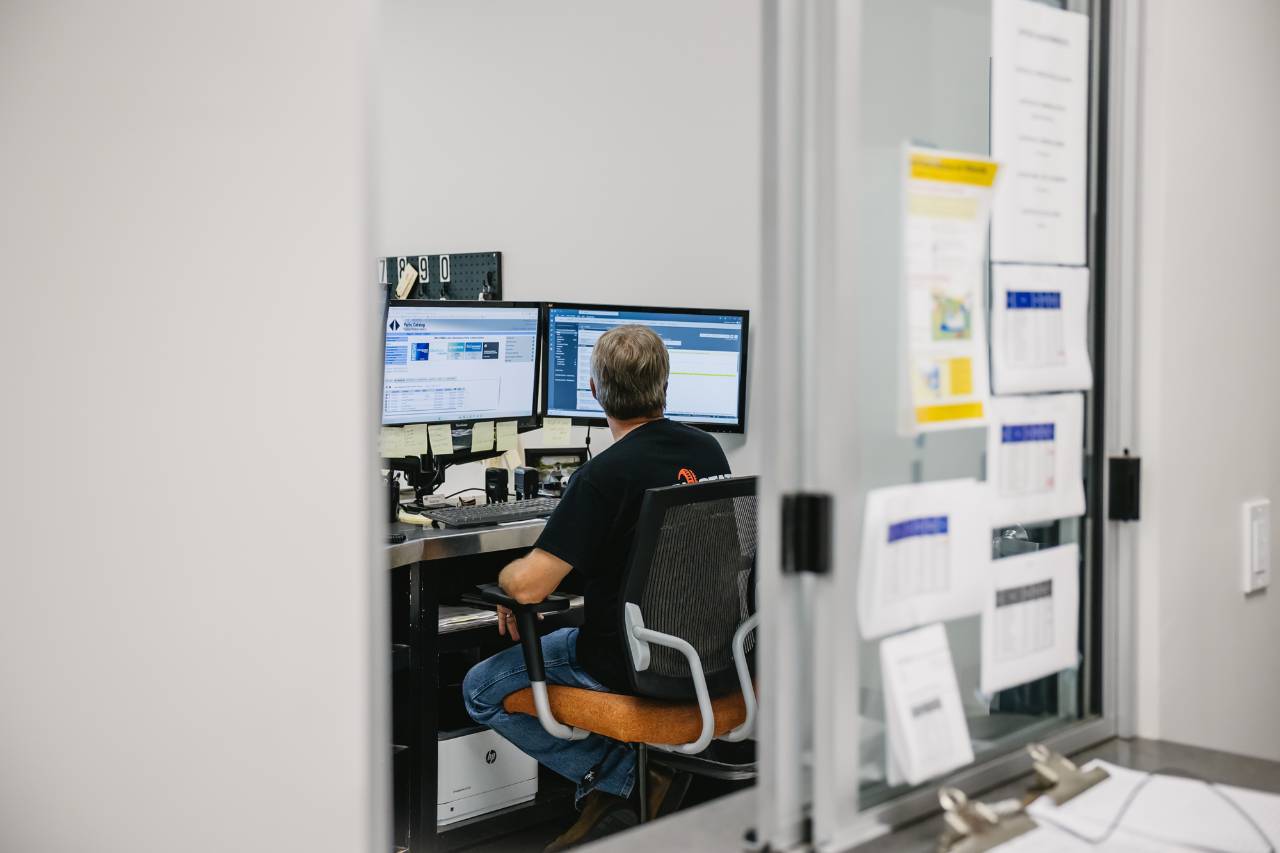 Parts counter employee looking up an International parts catalog on dual monitors