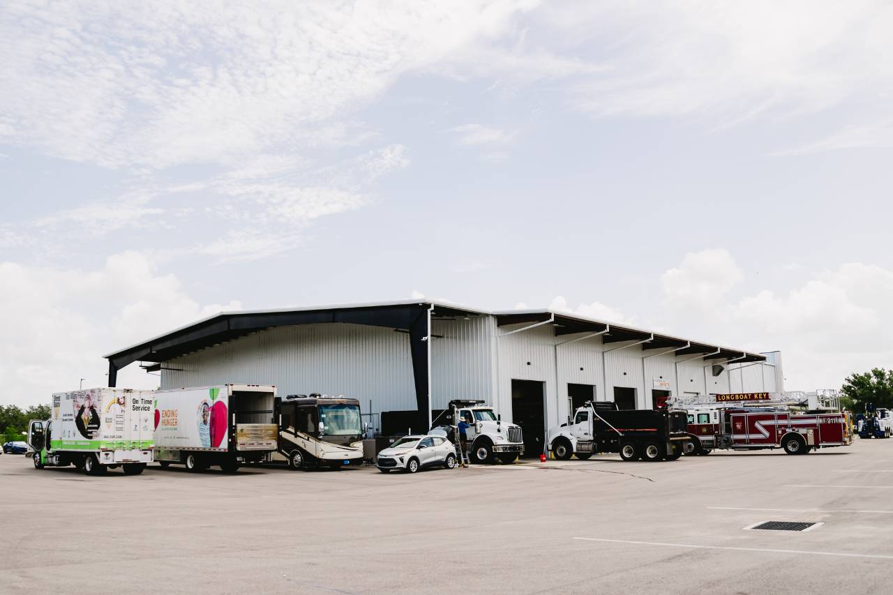 Exterior of the Sun State International service center with fleet vehicles parked outside