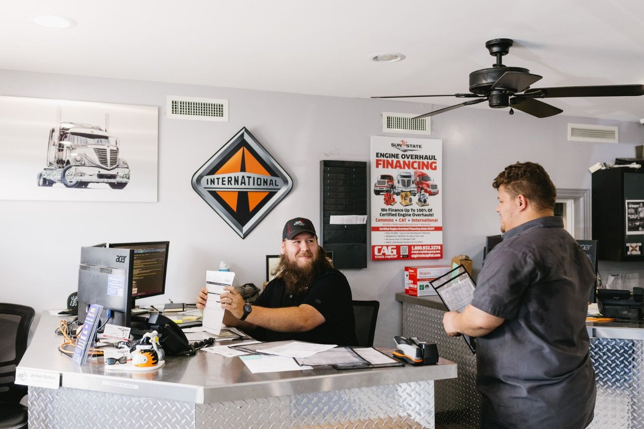 Sun State service advisor and technician reviewing a maintenance schedule at the counter