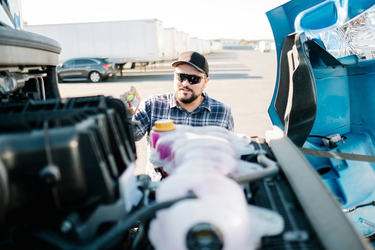 Technician performing a roadside repair check on an International truck engine