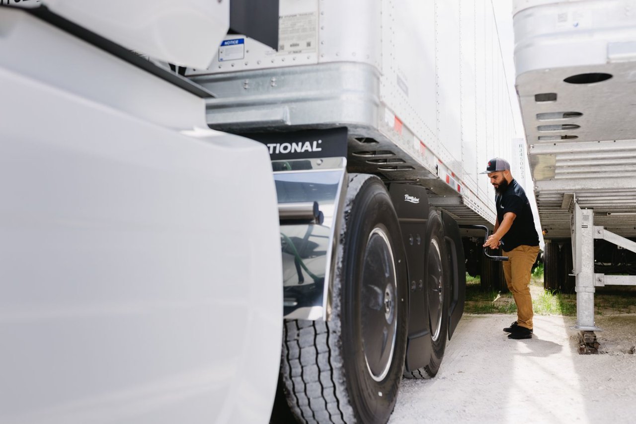 Sun State technician checking trailer wheels and coupling in the yard