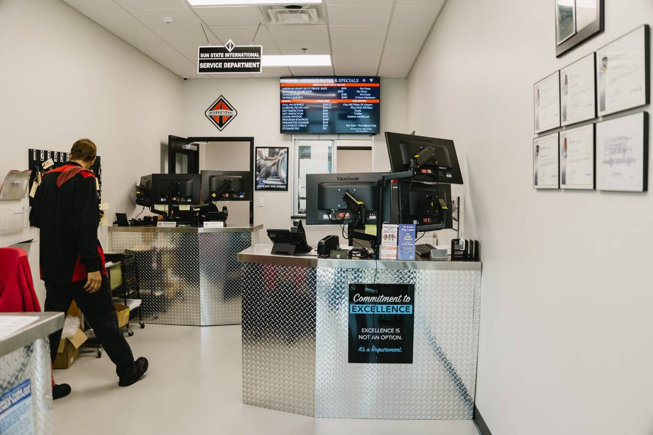Sun State International service department check-in counter with rates and specials board