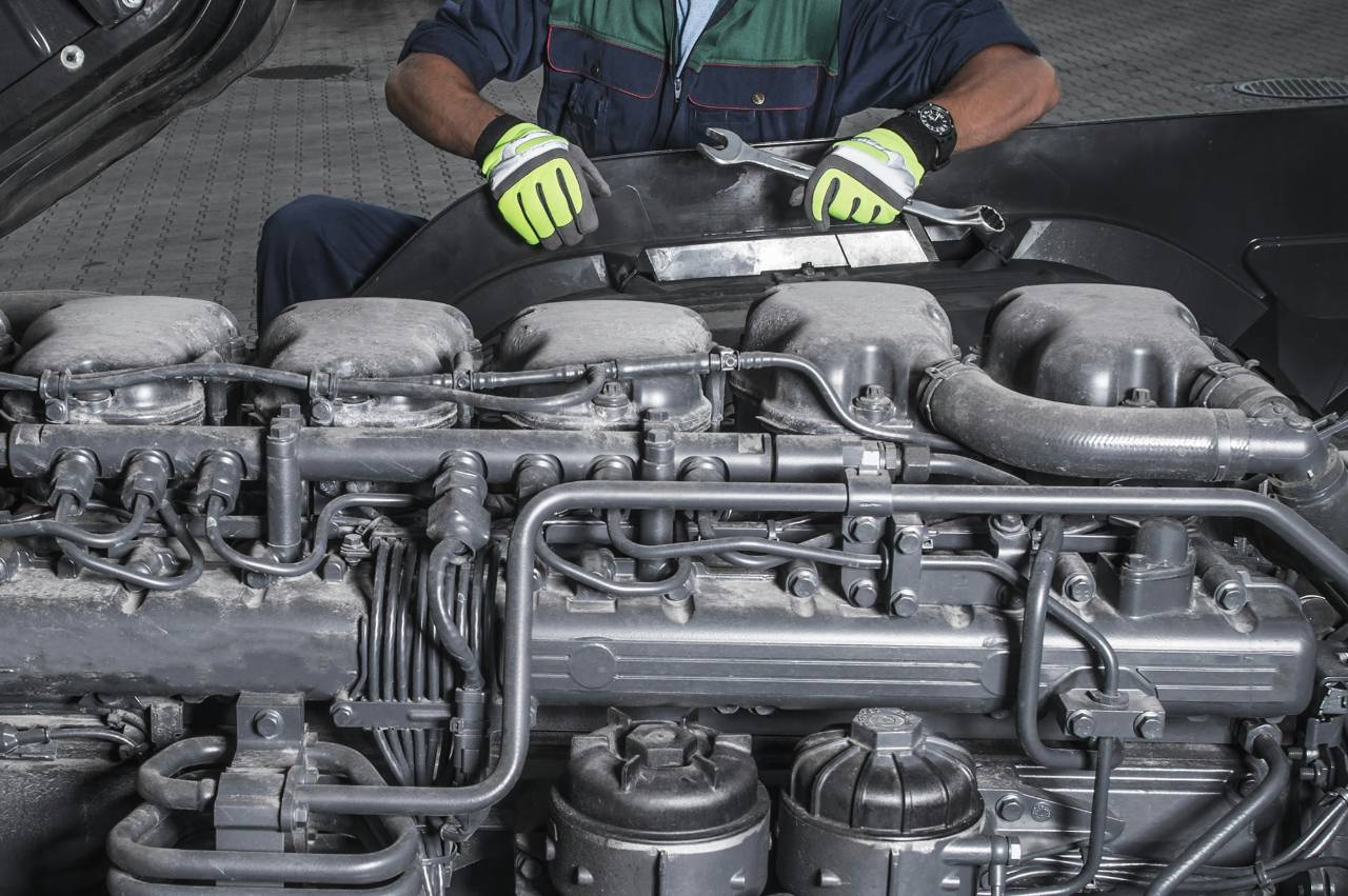 Technician using a wrench during commercial truck diesel repair service