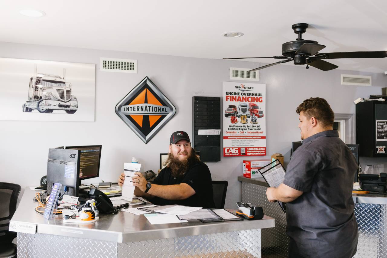 Sun State International parts staff reviewing a customer order at the front desk