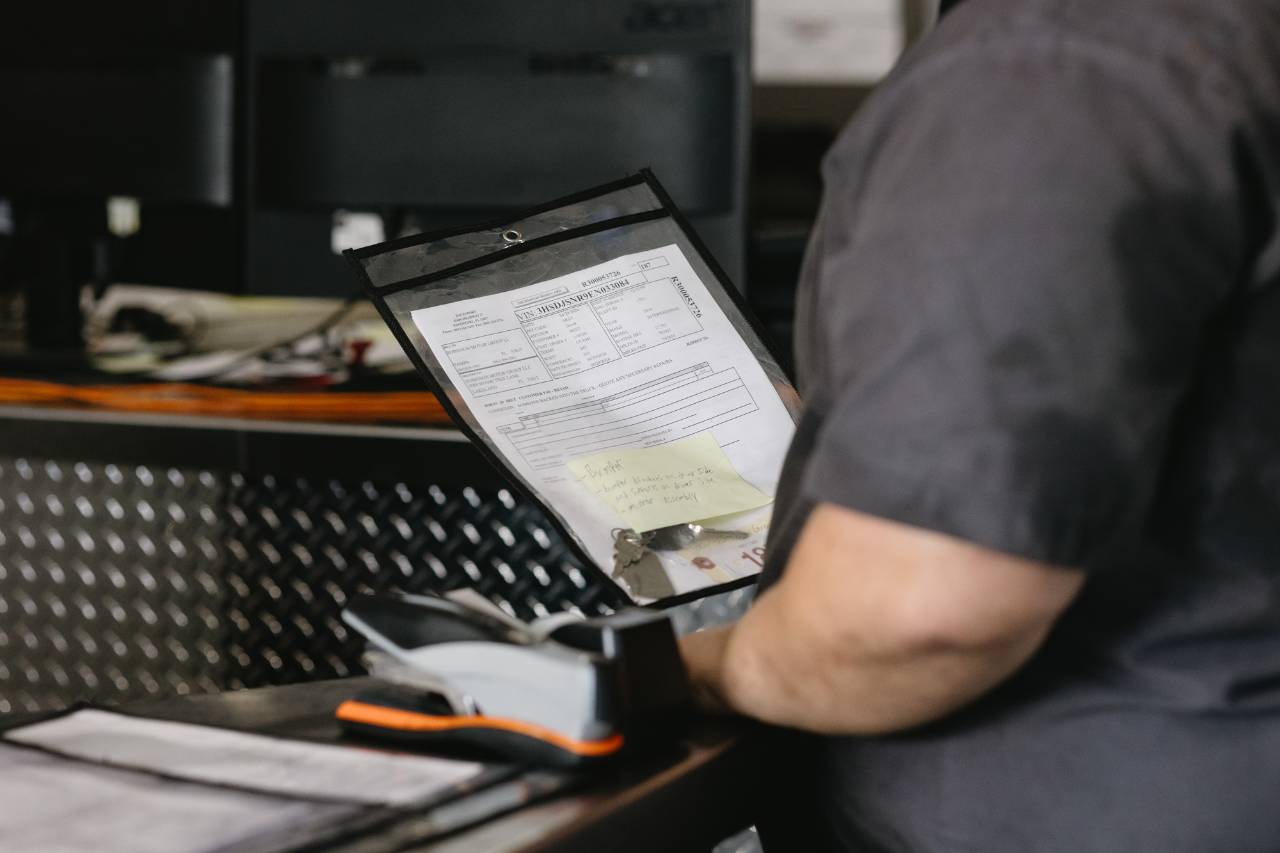 Sun State International technician reviewing a service work order at the front desk